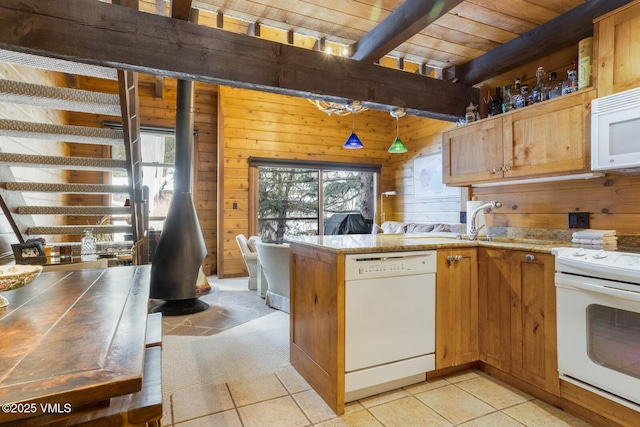 kitchen with white appliances, wood walls, wooden ceiling, a wood stove, and beam ceiling
