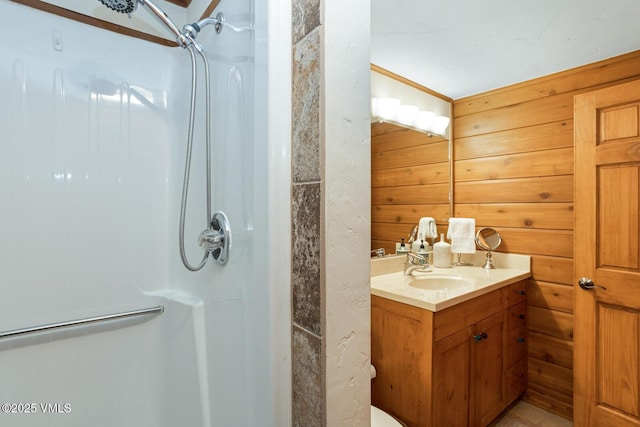 full bathroom featuring a shower, vanity, and wooden walls