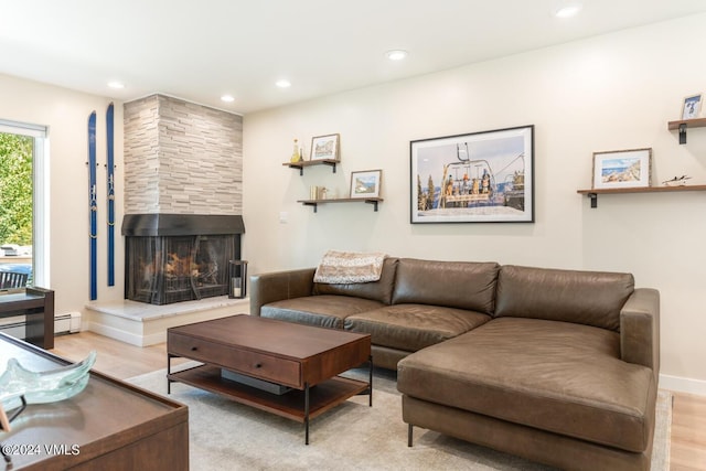 living area with recessed lighting, wood finished floors, baseboards, and a large fireplace