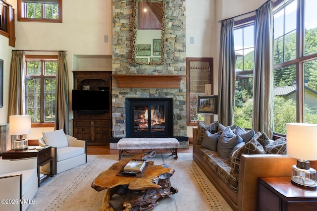 153 Village Walk, Beaver Creek, CO 81620 - living room featuring a high ceiling, a stone fireplace, and wood finished floors