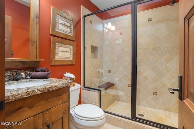 bathroom featuring vanity, an enclosed shower, and toilet