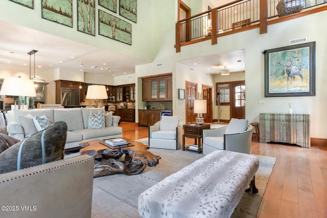 153 Village Walk, Beaver Creek, CO 81620 - living room featuring light wood-style flooring and a towering ceiling