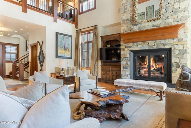 living room featuring a fireplace, wood-type flooring, and a high ceiling