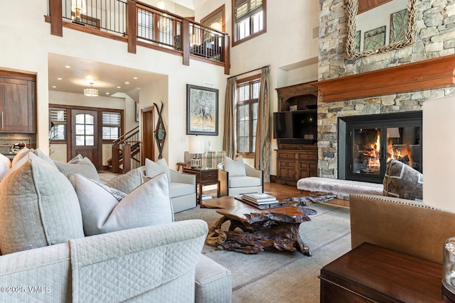 living room featuring a towering ceiling and a stone fireplace