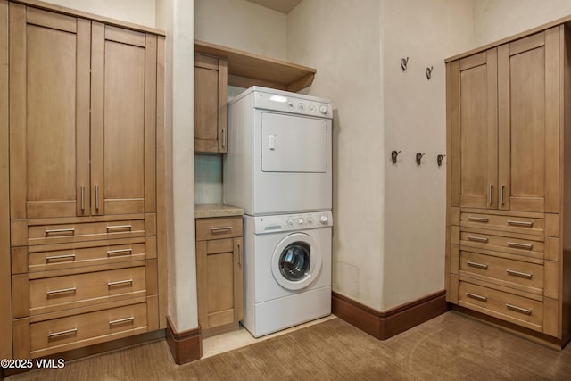 clothes washing area with cabinets, stacked washer / drying machine, and light carpet