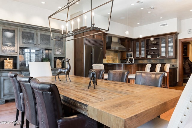 dining area featuring light hardwood / wood-style floors and a high ceiling