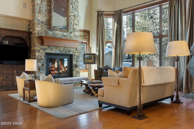 interior space featuring wood-type flooring, a fireplace, and a high ceiling