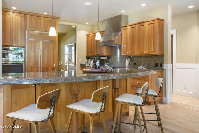 88 E Double Hitch, Eagle, CO 81631 - kitchen with wall chimney exhaust hood, stainless steel double oven, paneled fridge, backsplash, and recessed lighting