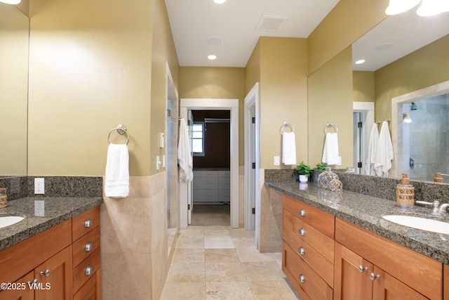 88 E Double Hitch, Eagle, CO 81631 - full bathroom featuring tile walls, two vanities, a shower stall, tile patterned floors, and a wainscoted wall
