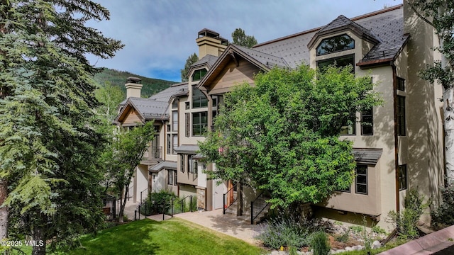 355 Offerson Rd Unit P4, Beaver Creek, CO 81620 - back of house with a chimney, stucco siding, and a yard