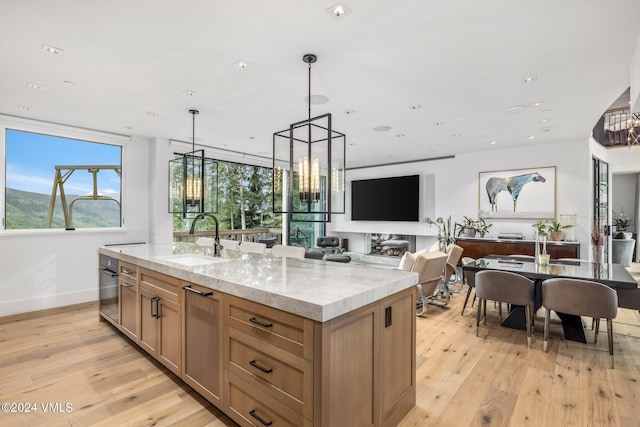 784 Potato Patch Dr Unit W, Vail, CO 81657 - kitchen with light wood finished floors, an island with sink, pendant lighting, recessed lighting, and light stone countertops