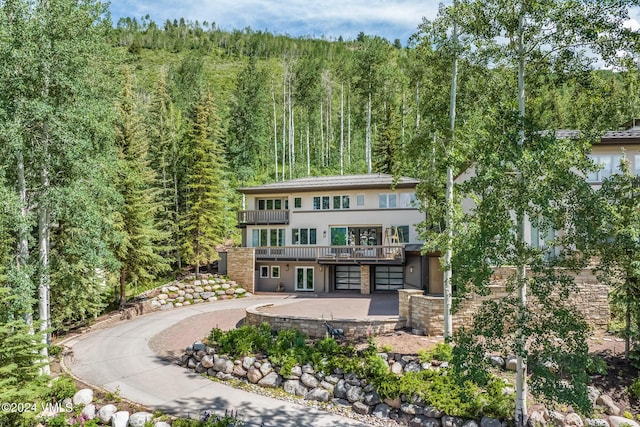 784 Potato Patch Dr Unit W, Vail, CO 81657 - view of front facade with a wooded view, stucco siding, a patio, a wooden deck, and french doors