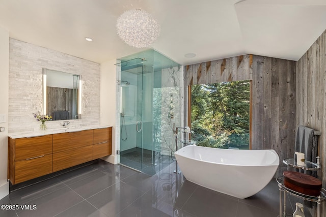 2764 S Frontage Rd, Vail, CO 81657 - full bathroom featuring vanity, a shower stall, wooden walls, a soaking tub, and vaulted ceiling