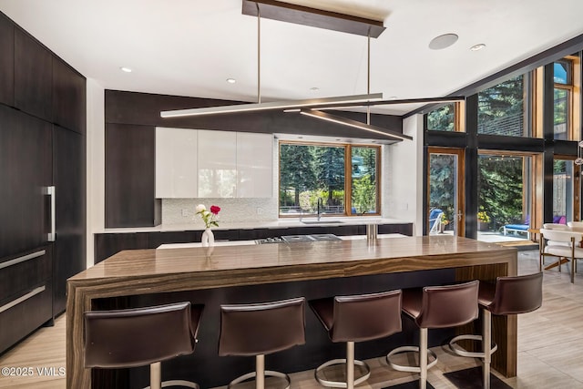 2764 S Frontage Rd, Vail, CO 81657 - kitchen featuring modern cabinets, a breakfast bar, a center island, and backsplash