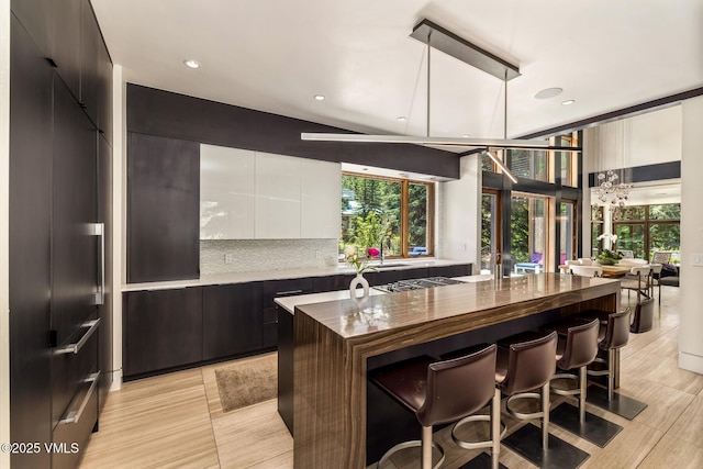 2764 S Frontage Rd, Vail, CO 81657 - kitchen featuring modern cabinets, white cabinetry, a kitchen breakfast bar, recessed lighting, and a kitchen island