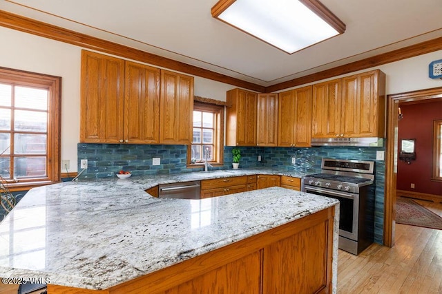336 E Fourth St, Eagle, CO 81631 - kitchen with appliances with stainless steel finishes, under cabinet range hood, a peninsula, decorative backsplash, and light stone countertops