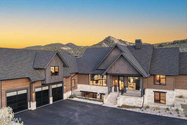 1092 Fourth Of July Rd, Eagle, CO 81631 - modern home featuring stone siding, a mountain view, asphalt driveway, an attached garage, and roof with shingles