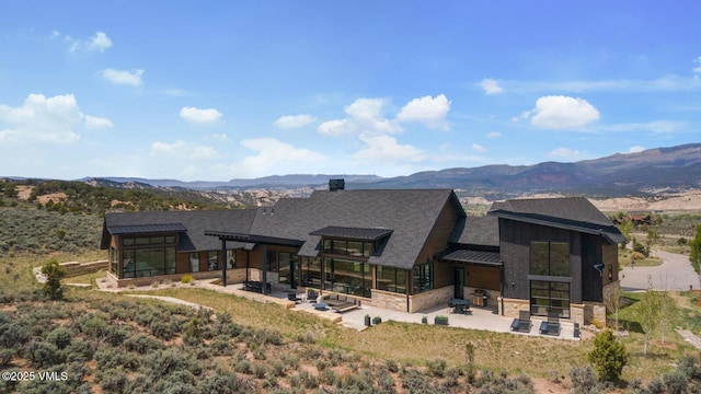 1092 Fourth Of July Rd, Eagle, CO 81631 - back of house featuring a patio area, a mountain view, stone siding, and a standing seam roof