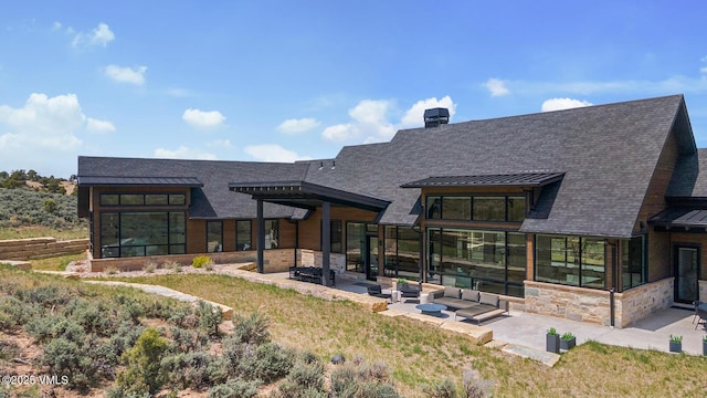 1092 Fourth Of July Rd, Eagle, CO 81631 - back of property with a standing seam roof, a patio area, stone siding, metal roof, and roof with shingles