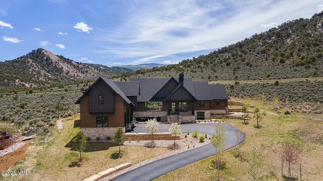 1092 Fourth Of July Rd, Eagle, CO 81631 - view of front of home featuring a chimney, a mountain view, driveway, roof with shingles, and covered porch
