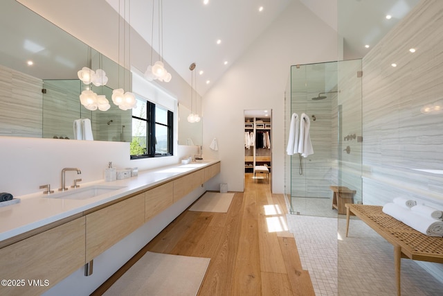 1092 Fourth Of July Rd, Eagle, CO 81631 - bathroom with wood finished floors, double vanity, tiled shower, high vaulted ceiling, and a walk in closet