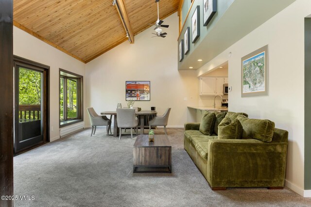 26 Lark Ct Unit B, Eagle-Vail, CO 81620 - living room featuring wooden ceiling with exposed beams, carpet floors, baseboards, high vaulted ceiling, and a ceiling fan