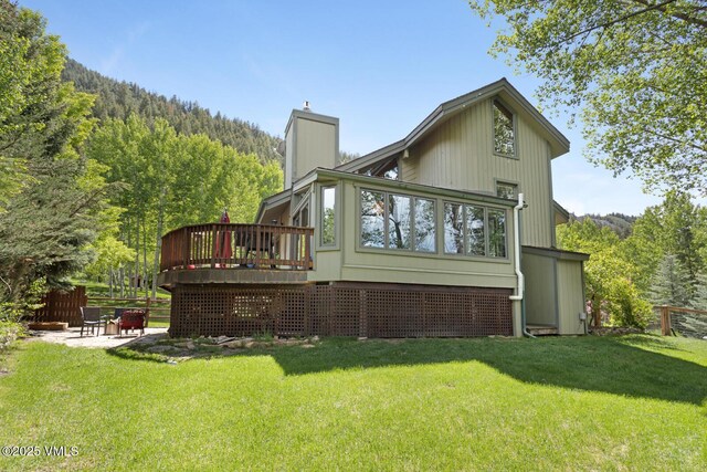 26 Lark Ct Unit B, Eagle-Vail, CO 81620 - rear view of house with a chimney, a deck, a patio, and a forest view