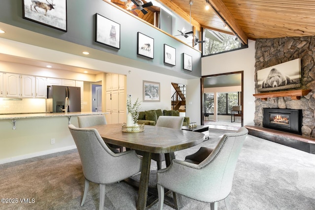 26 Lark Ct Unit B, Eagle-Vail, CO 81620 - carpeted dining space featuring wood ceiling, a stone fireplace, healthy amount of natural light, high vaulted ceiling, and a ceiling fan