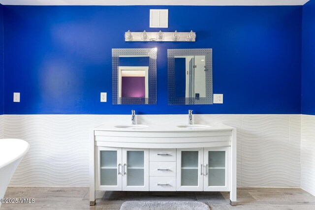 26 Lark Ct Unit B, Eagle-Vail, CO 81620 - bathroom with a soaking tub, double vanity, and wainscoting
