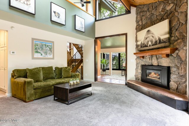 26 Lark Ct Unit B, Eagle-Vail, CO 81620 - living room with carpet flooring, a high ceiling, stairs, a fireplace, and baseboards