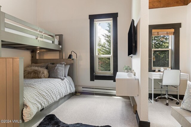 carpeted bedroom featuring a baseboard heating unit