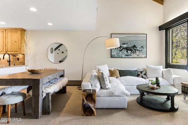 living room with a baseboard heating unit, carpet, and sink