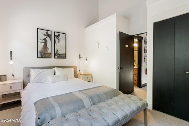 bedroom with a high ceiling, light colored carpet, and a closet