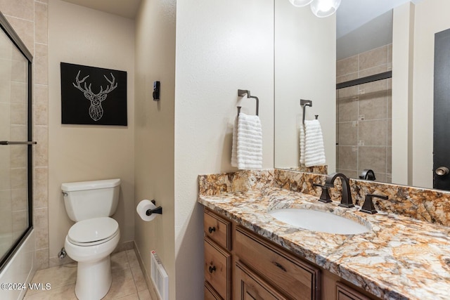 full bathroom featuring vanity, tile patterned floors, shower / bath combination with glass door, and toilet