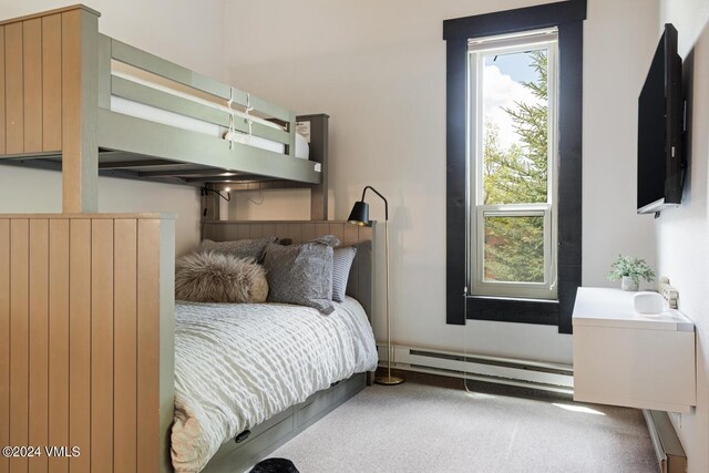 carpeted bedroom featuring a baseboard heating unit