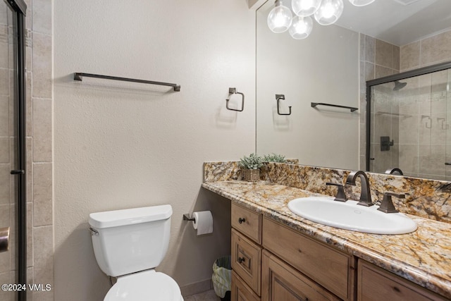 bathroom with an enclosed shower, vanity, and toilet