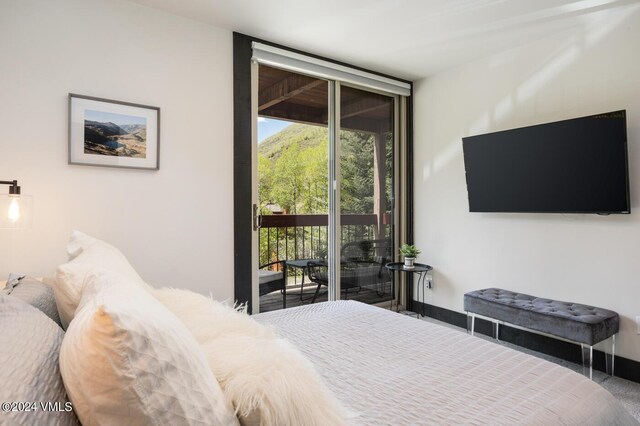 bedroom featuring expansive windows and access to outside