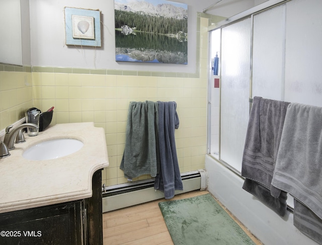 425 Broadway St, Eagle, CO 81631 - bathroom featuring a baseboard heating unit, shower / bath combination with glass door, tile walls, and wood finished floors