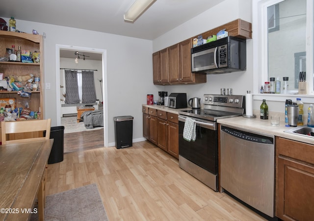 425 Broadway St, Eagle, CO 81631 - kitchen featuring light wood finished floors, baseboards, light countertops, appliances with stainless steel finishes, and open shelves