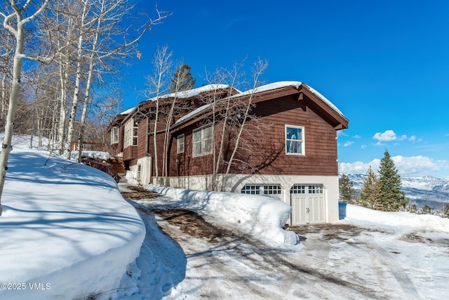 view of snowy exterior featuring a garage