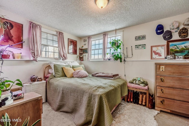 carpeted bedroom featuring multiple windows and a textured ceiling