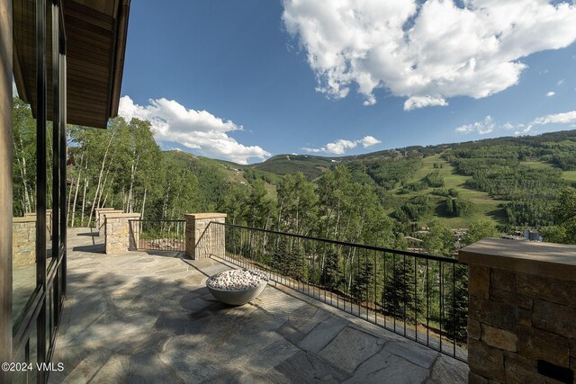 view of patio with a mountain view and a view of trees