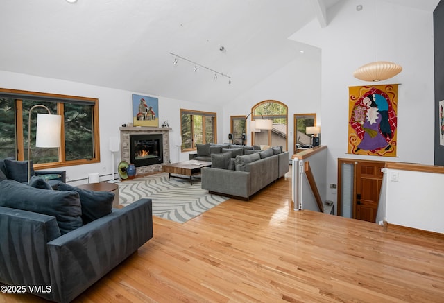 1460 Buffehr Creek Rd Unit C, Vail, CO 81657 - living room with wood finished floors, track lighting, high vaulted ceiling, a glass covered fireplace, and a baseboard radiator