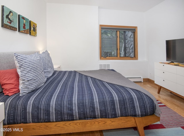 1460 Buffehr Creek Rd Unit C, Vail, CO 81657 - bedroom featuring a baseboard radiator, wood finished floors, and baseboards