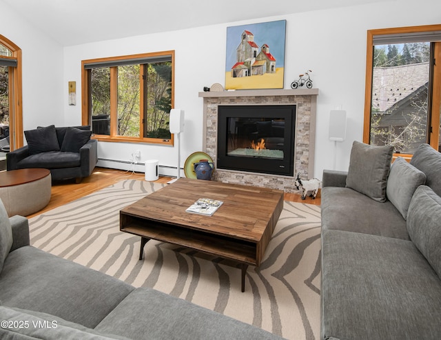 1460 Buffehr Creek Rd Unit C, Vail, CO 81657 - living room featuring a glass covered fireplace, wood finished floors, and a baseboard radiator