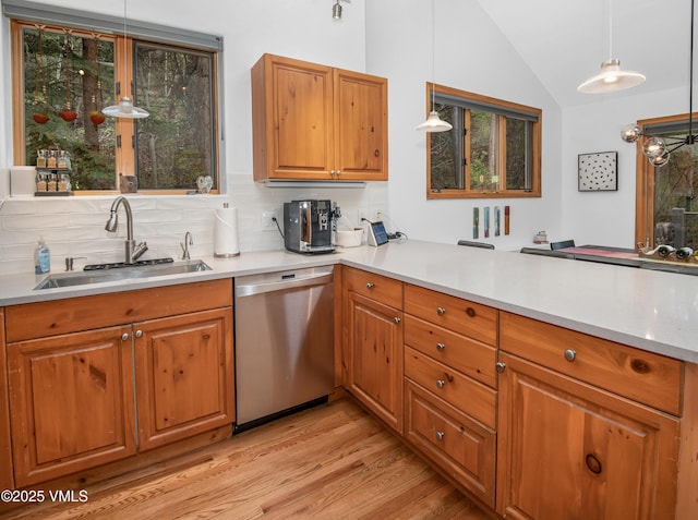 1460 Buffehr Creek Rd Unit C, Vail, CO 81657 - kitchen with stainless steel dishwasher, a sink, lofted ceiling, light wood-style flooring, and a peninsula