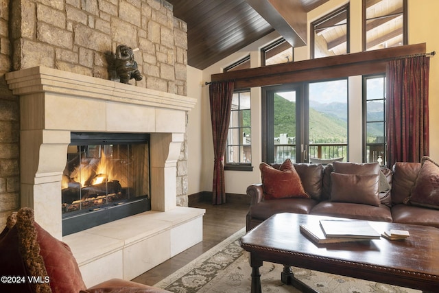 living room with wood ceiling, lofted ceiling with beams, dark hardwood / wood-style floors, a mountain view, and a tiled fireplace