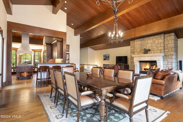 dining space featuring a notable chandelier, a fireplace, and hardwood / wood-style floors