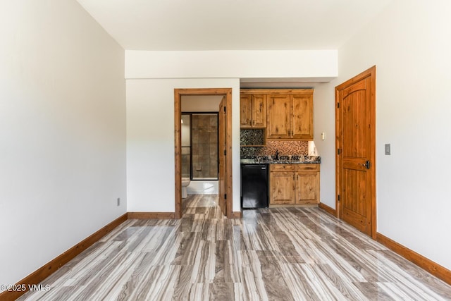 416 Eby Creek Rd, Eagle, CO 81631 - kitchen featuring dishwasher, dark countertops, light wood-style flooring, decorative backsplash, and brown cabinetry