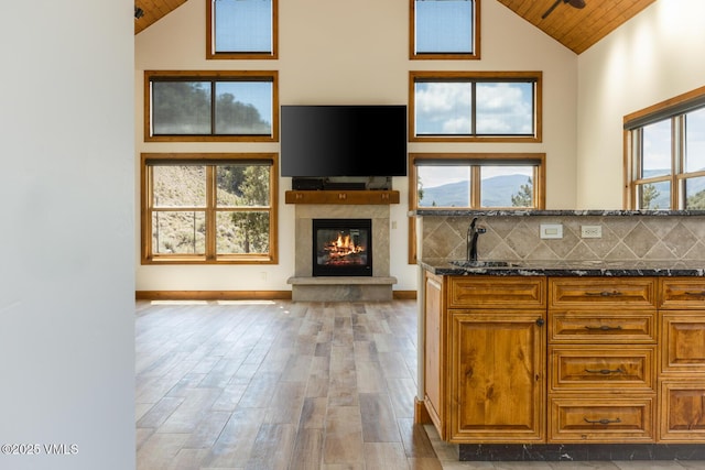 416 Eby Creek Rd, Eagle, CO 81631 - kitchen with wood ceiling, high vaulted ceiling, dark stone counters, a glass covered fireplace, and wood finished floors